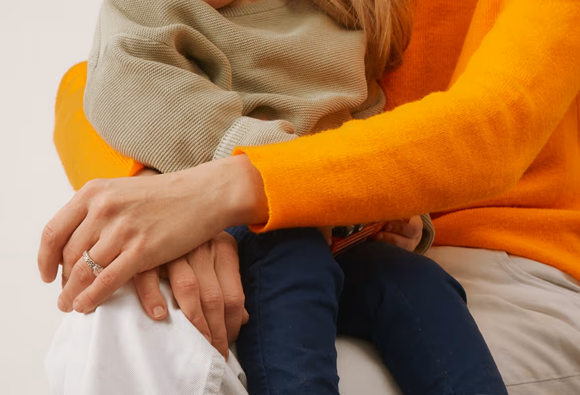 Woman with bright orange sweater holding child on her lap. Found on Death to Stock :"Parenthood" Shot by Daniel Farò