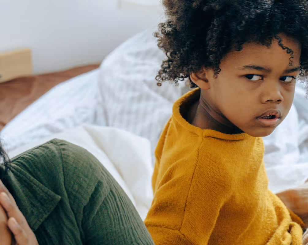 Child in an orange sweater giving the bitter side eye to the left. Found on Pexels Shot by Ketut Subiyanto